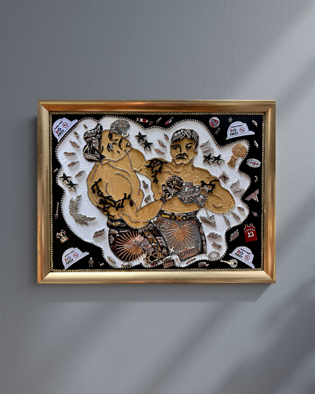 A framed 3D wall art piece depicting two boxing figures with various boxing-themed elements, mounted on a gray wall.